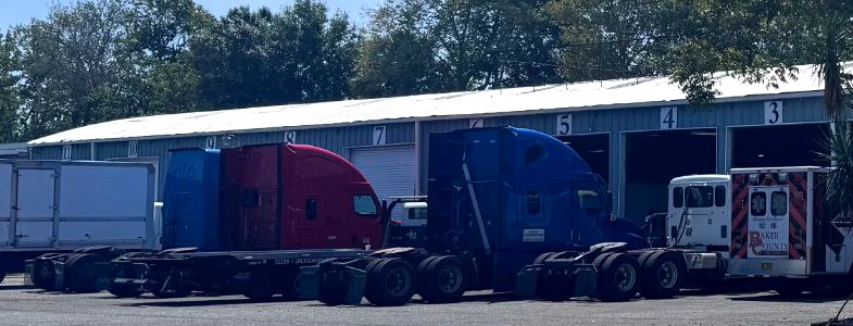 The bay line at Allstate Auto & Truck Repair on W Beaver St, with tractors in the numbered bays